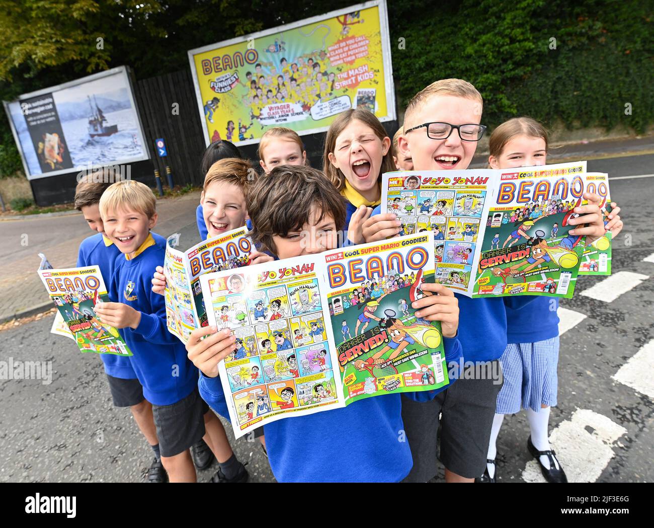 USO EDITORIALE SOLO gli allievi della classe Voyager Year 5 alla Whitehill Junior School svelano un cartellone che illustra il loro scherzo vincente mentre vengono presentati con il trofeo Beano 'Britain's Funniest Class' dal fumettista Danny Pearson, Hertfordshire. Data foto: Mercoledì 29 giugno 2022. La classe si è rivolta alla barzelletta vincente: "Che cosa chiami una classe di bambini che mangiano patate usando le dita dei piedi? - The Mash Street Kids!". La competizione è stata feroce quest'anno con scherzi esilaranti provenienti da tutta la nazione e ricevendo oltre 190.000 voti dal pubblico. L'iniziativa annuale, cr Foto Stock