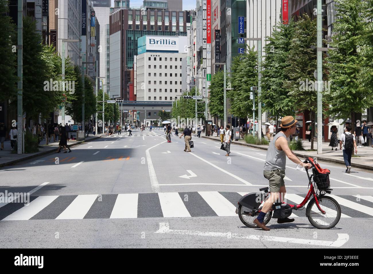 TOKYO, GIAPPONE (26/6/2022) - strada principale di Ginza che è chiusa al traffico in una giornata 'paradiso pedonale'. La gente cammina all'ombra in una giornata calda. Foto Stock