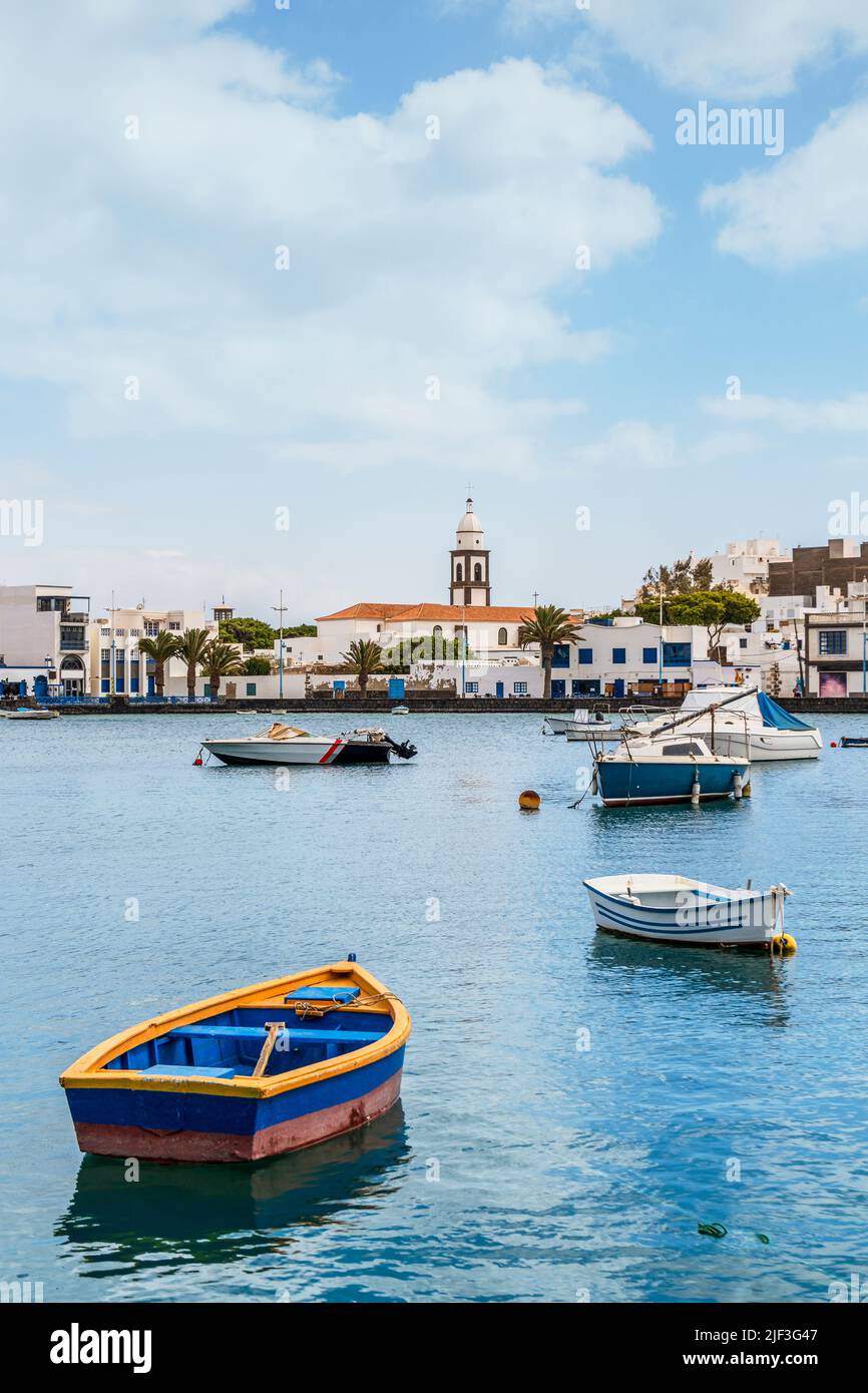 Bellissimo molo con architettura storica e barche sulle acque blu in Arrecife, Lanzarote, Isole Canarie, Spagna Foto Stock