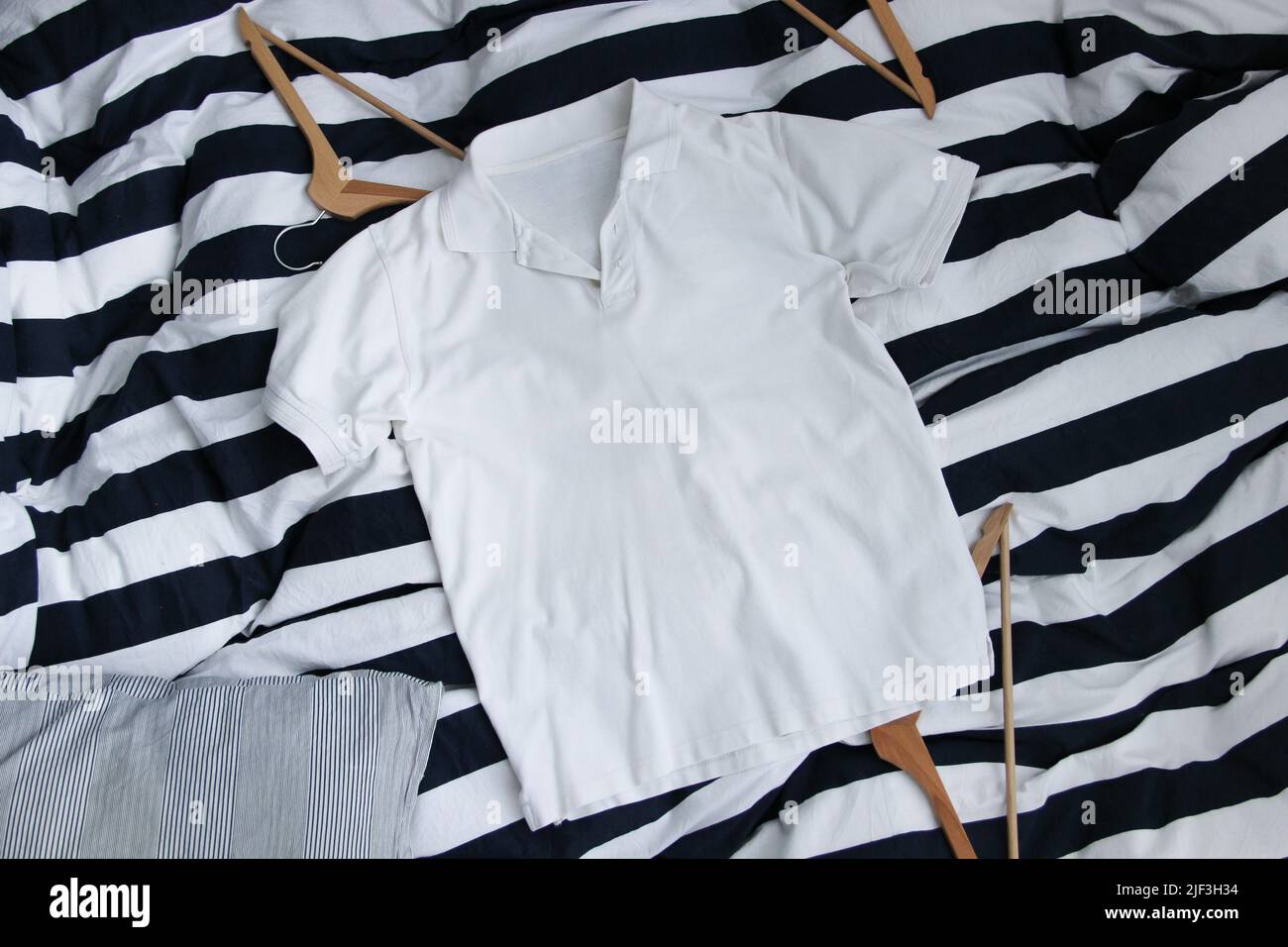 Camicia da golf in cotone bianco mockup sullo sfondo a righe. Camicia da golf classica in bianco. Foto Stock