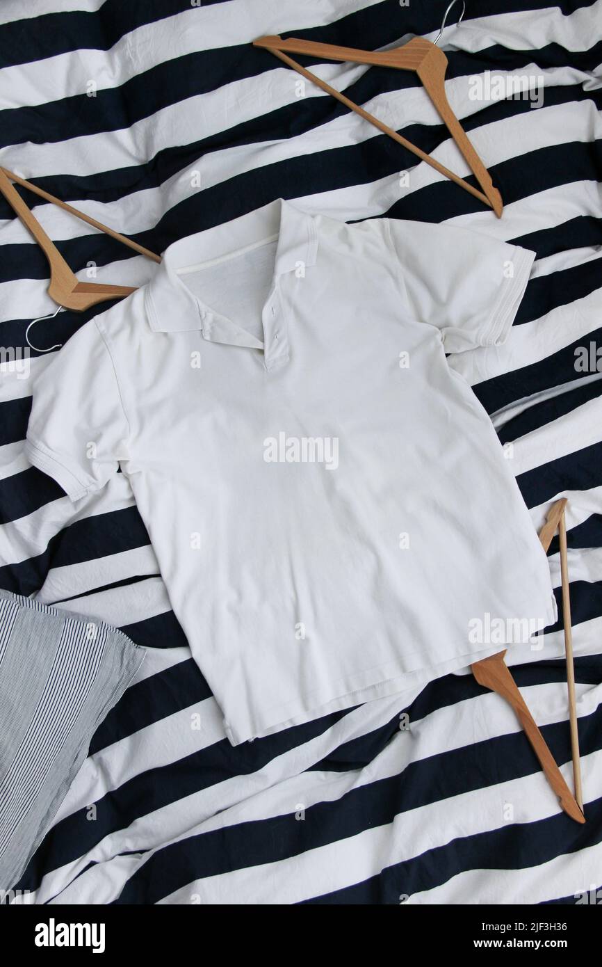 Camicia da golf in cotone bianco mockup sullo sfondo a righe. Camicia da golf classica in bianco. Foto Stock