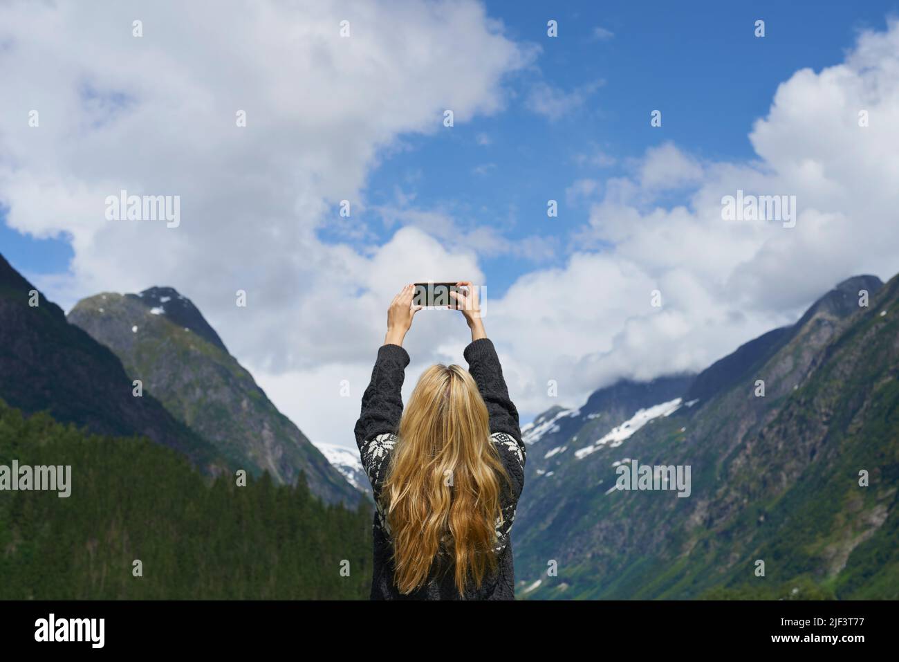 Avventura donna fotografando lo smartphone del paesaggio glaciale della valle durante l'esplorazione di viaggi per i social media Foto Stock