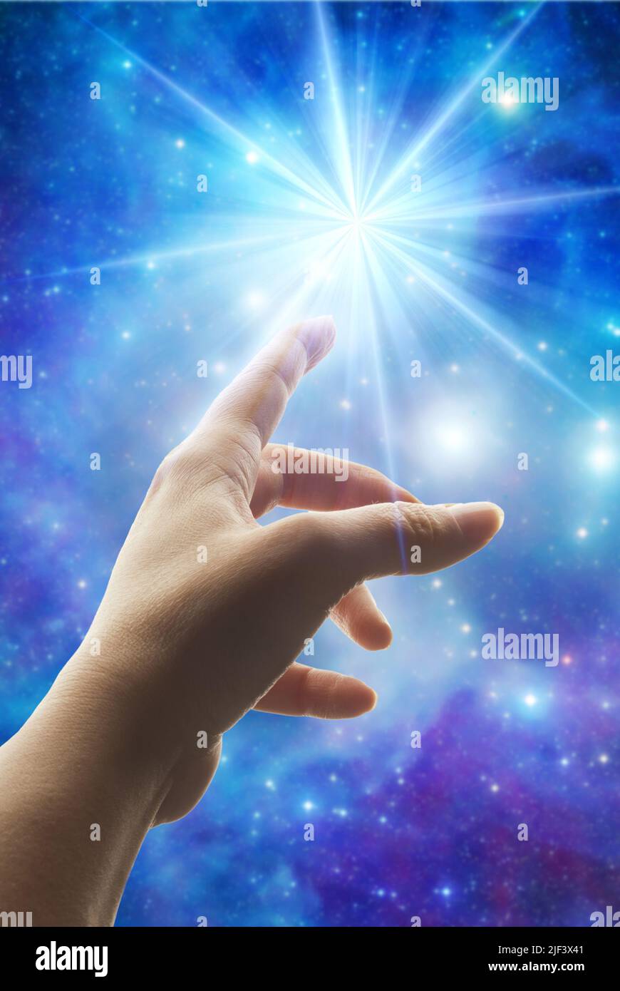 donna che punta il dito verso una luce divina nel cielo Foto Stock