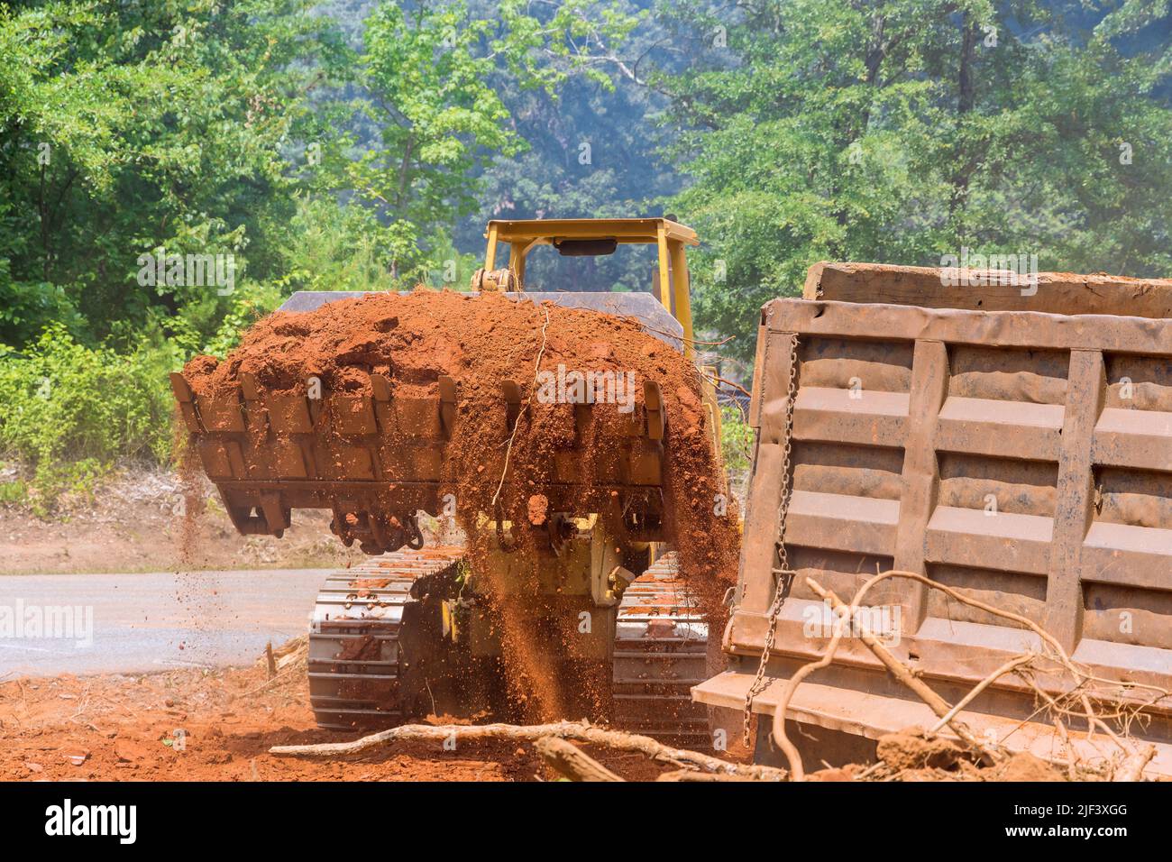 Lavori in cantiere con l'escavatore che carica il terreno nei dumper Foto Stock