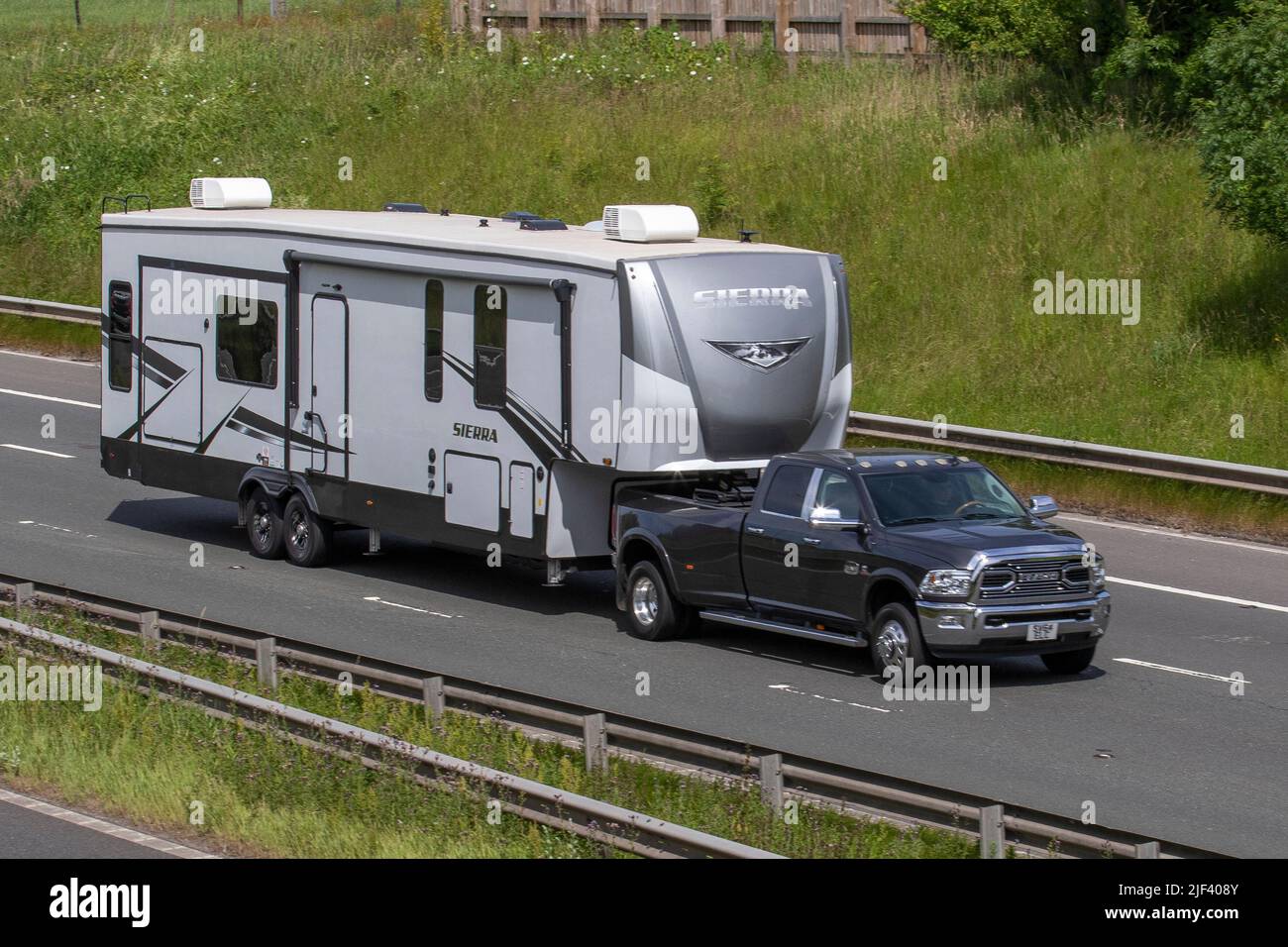 2015 American Dodge RAM Guida a sinistra LCV 6700cc Diesel Truck Training grande SIERRA Bunkhouse RV rimorchio viaggio sul M61 autostrada vicino Manchester, Regno Unito Foto Stock