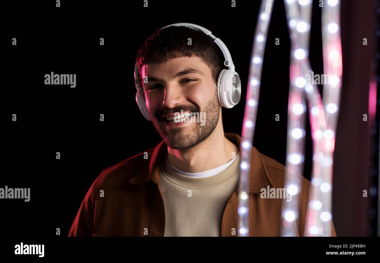 L'uomo nelle cuffie oltre le luci al neon di night club Foto Stock