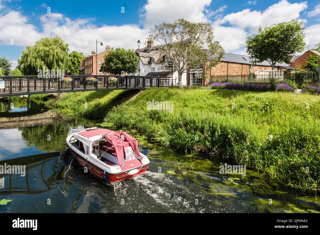 Un taxi d'acqua che passa sotto la passerella sul fiume Welland. Spalding, Lincolnshire, Inghilterra, Regno Unito, Gran Bretagna Foto Stock