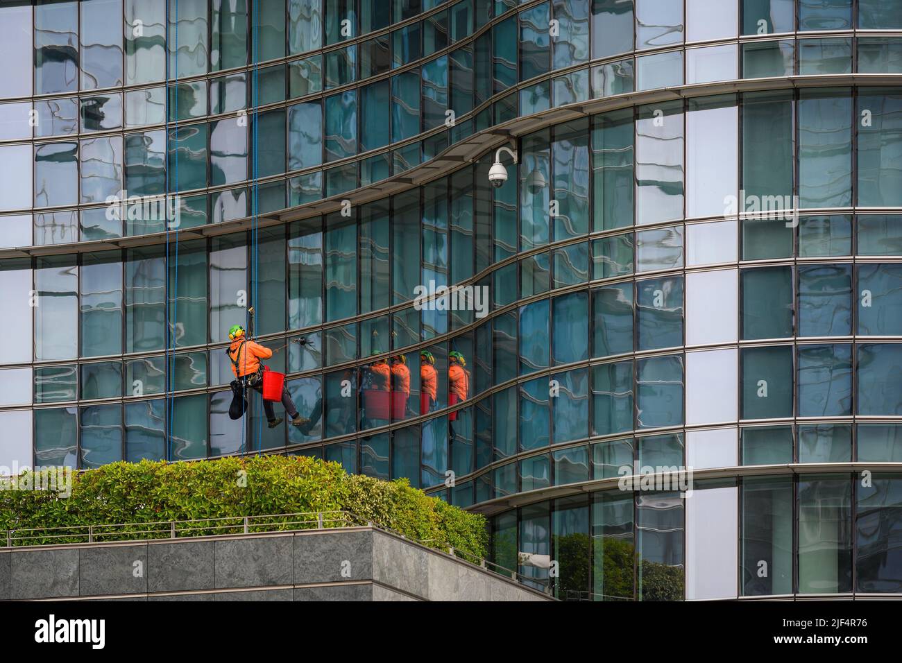 I lavoratori puliscono le finestre in un alto edificio Foto Stock
