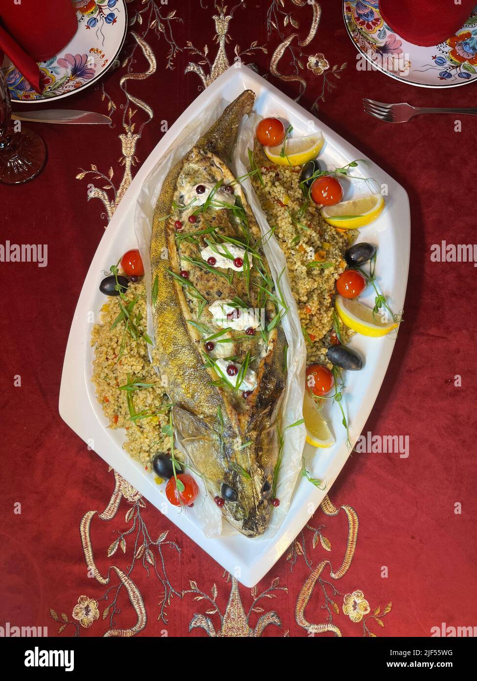 Piatti di pesce al forno con un contorno su un piatto bianco vista dall'alto Foto Stock