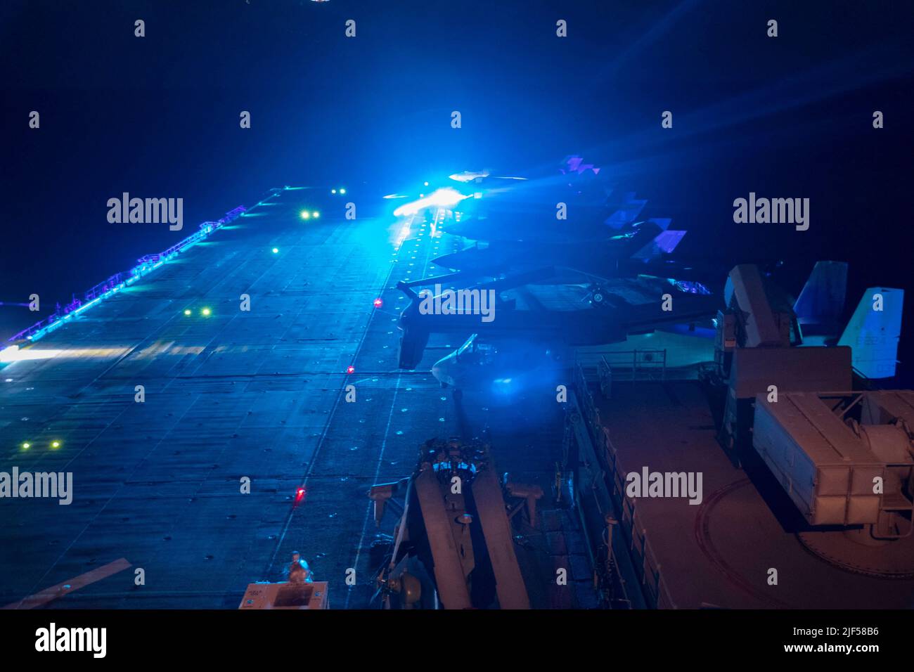 220629-N-XN177-1059 EAST CHINA SEA (29 giugno 2022) – i marinai guidano un trattore sul ponte di volo della nave d'assalto anfibio USS Tripoli (LHA 7), 29 giugno 2022. Tripoli opera nell'area operativa della flotta USA 7th per migliorare l'interoperabilità con alleati e partner e servire come forza di risposta pronta a difendere la pace e mantenere la stabilità nella regione Indo-Pacific. (STATI UNITI Foto Navy di Mass Communication Specialist 1st Classe Peter Burghart) Foto Stock