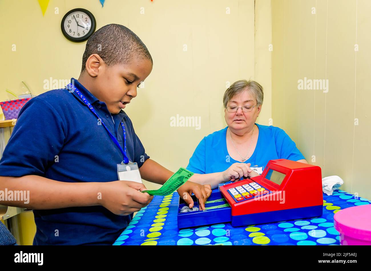 Un tutor volontario aiuta uno studente a fare il cambiamento con un registratore di cassa giocattolo presso un centro di tutoring post-scuola, 28 febbraio 2013, a Columbus, Mississippi. Foto Stock