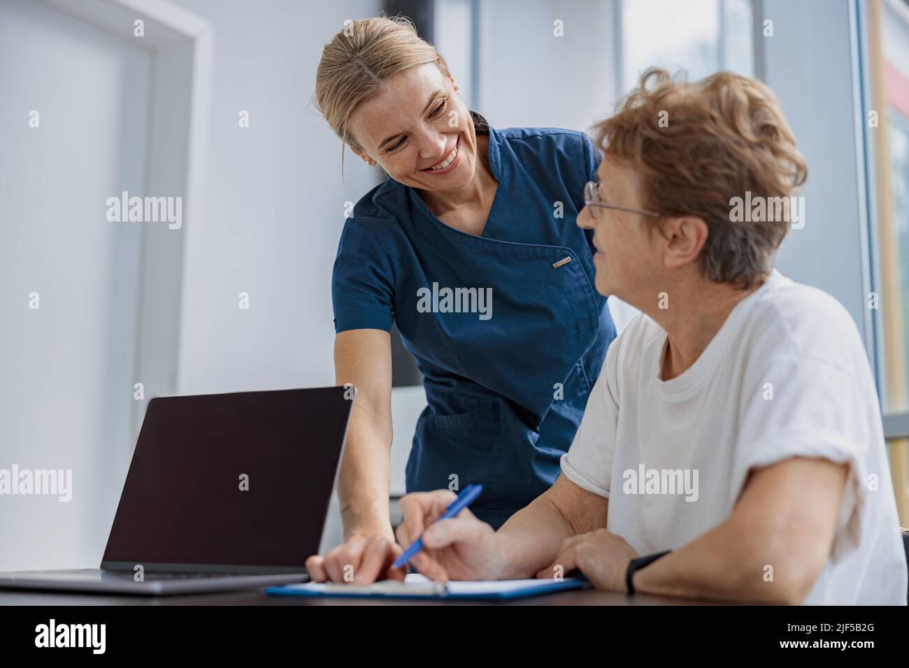 Documento legale assicurazione di riempimento paziente femminile su appuntamento con il medico in clinica Foto Stock