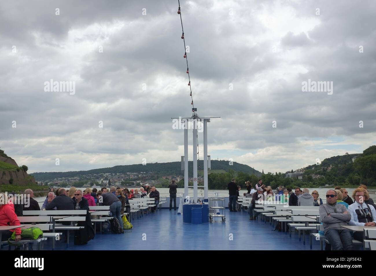 Ponte superiore del traghetto Bingen-Rudesheimer. I turisti sulle panchine si godono la crociera panoramica attraverso il Medio Reno in Renania-Palatinato, Germania. Foto Stock