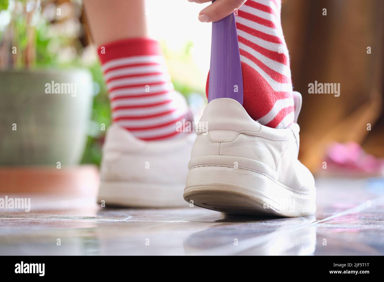 Indossare scarpe atletiche con il cucchiaio per scarpe da closeup Foto Stock