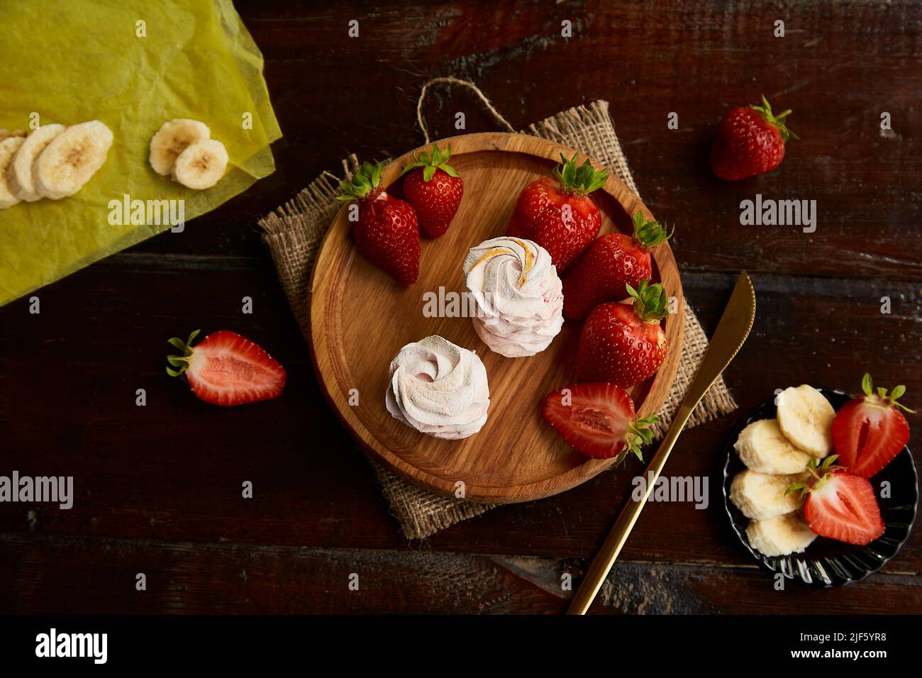 Marshmallows con gusto di banana e fragola su piatto di legno. Cibo sano, naturale senza zucchero vanigliato cibo Foto Stock