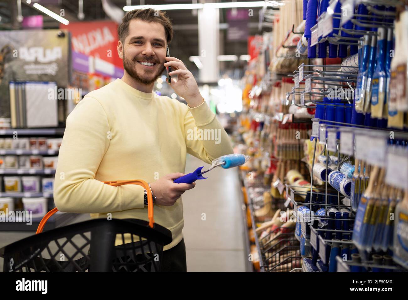 carrello in mani parlando al telefono in un negozio di materiali per costruzioni e finiture Foto Stock
