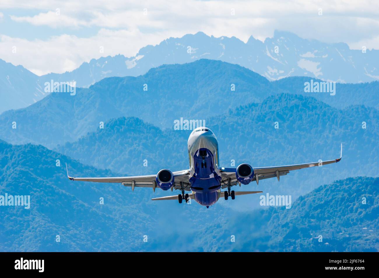 Moderno aereo di linea sorge sullo sfondo delle montagne Foto Stock