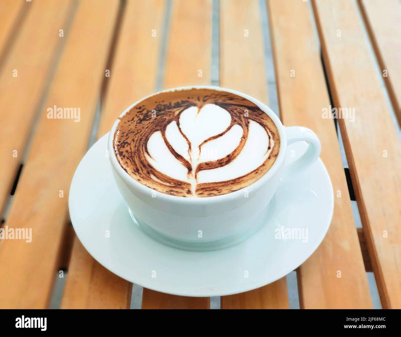 Caffè ad alta angolazione latte art su tavolo in legno nella caffetteria Foto Stock