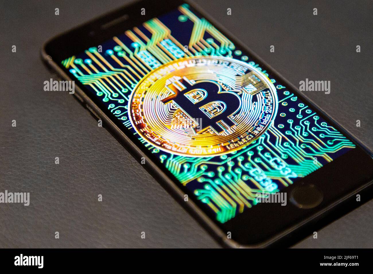 Logo Bitcoin sullo schermo di un telefono su sfondo in pelle Foto Stock