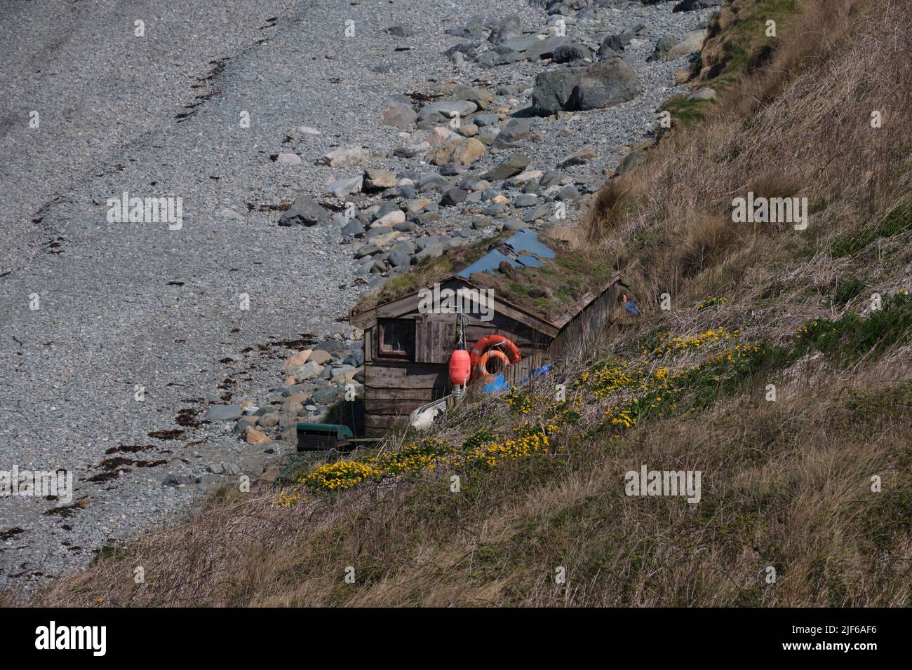 Una capanna rustica annidata in una baia vicino a Porth Dulllaen sul Wales Coast Path. Foto Stock