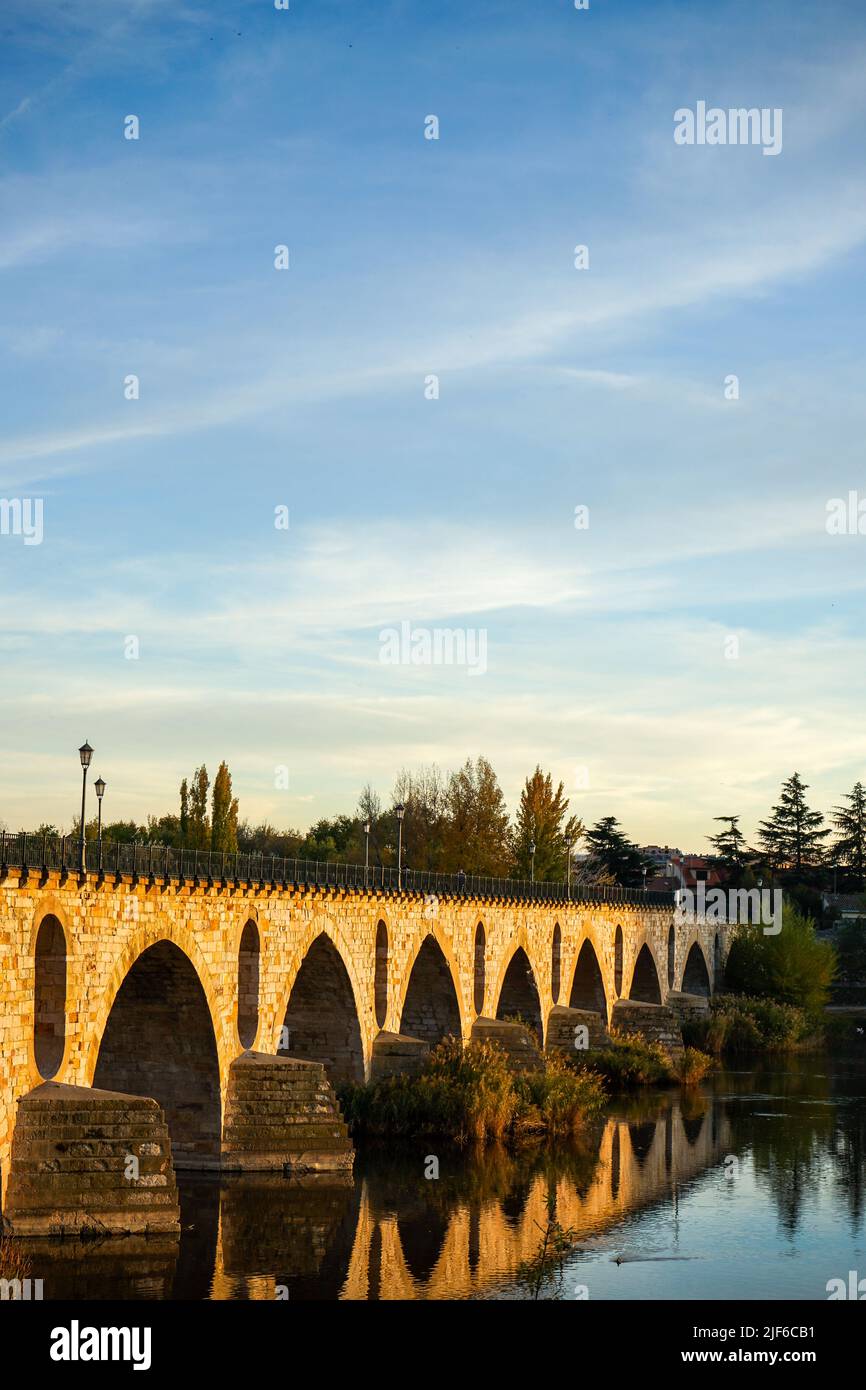 Storico ponte in pietra sul fiume Douro, ora del tramonto. Foto Stock