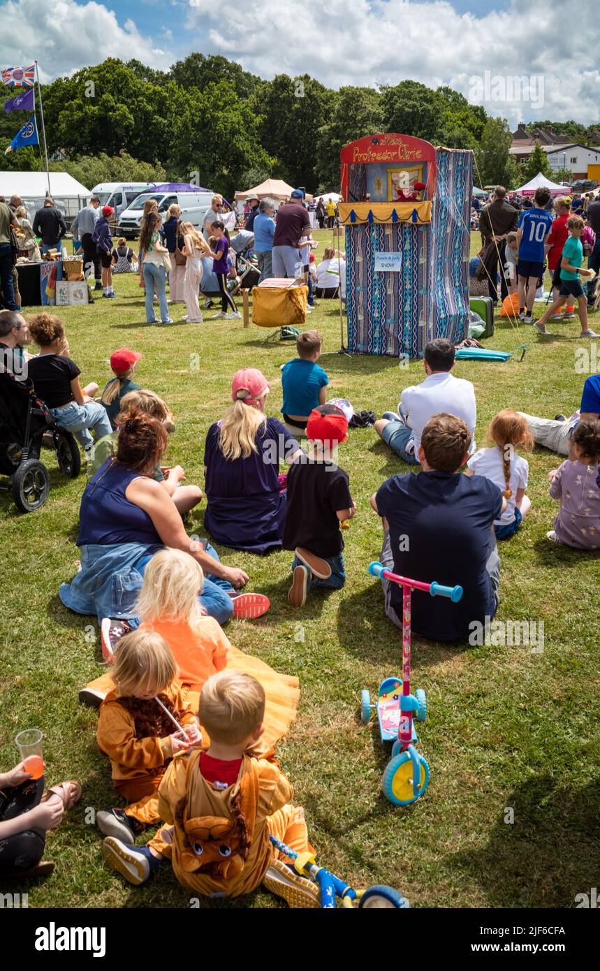 Le famiglie guardano un tradizionale spettacolo di burattini Punch & Judy al Billingshurst Show nel West Sussex, Regno Unito. Foto Stock