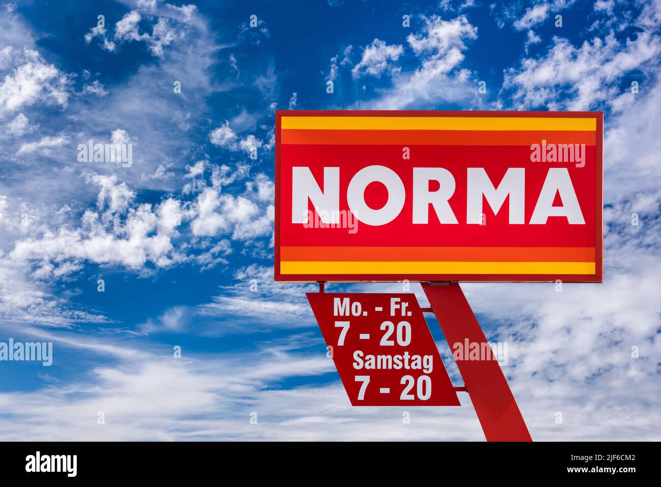 AUGSBURG, GERMANIA – 16 GIUGNO 2022: Segno pubblicitario del negozio discounter NORMA di fronte a un cielo con le nuvole Foto Stock