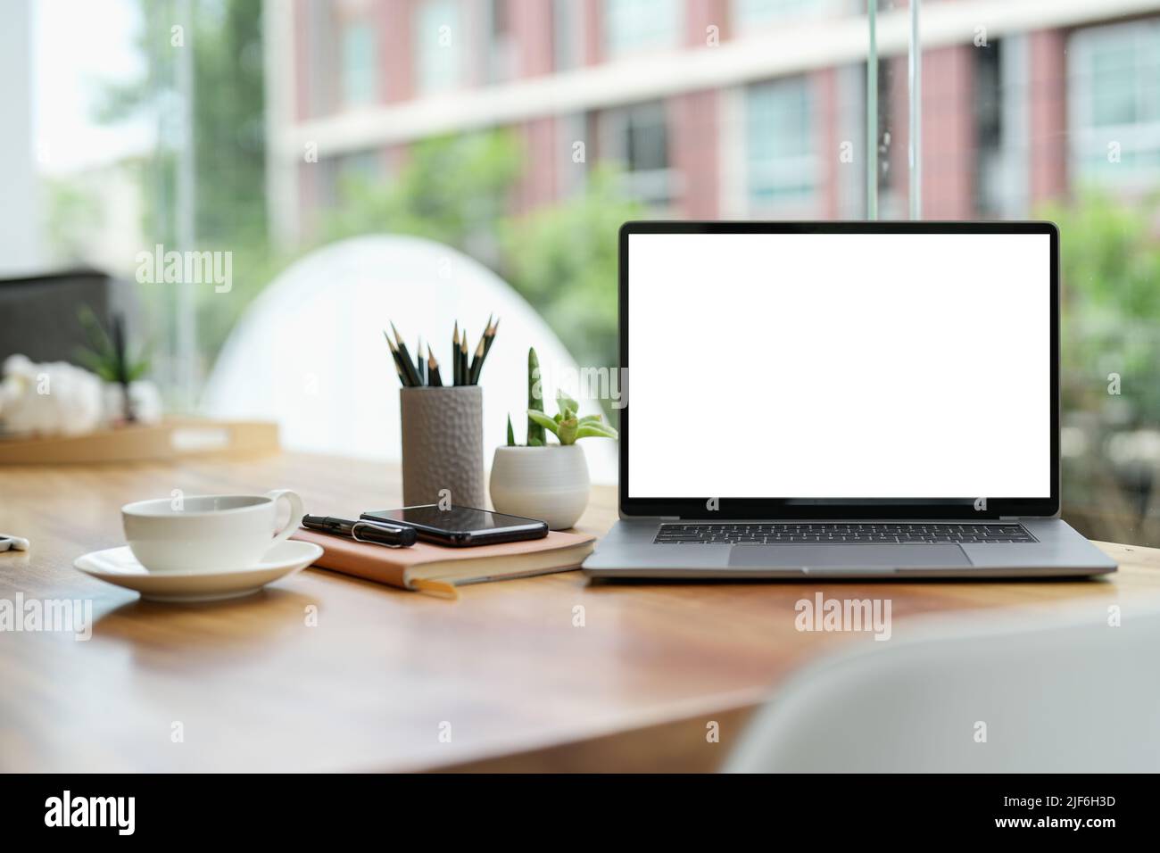 Schermo vuoto del computer portatile su un tavolo in legno con sfondo caffè, mockup, modello per il tuo testo, Foto Stock