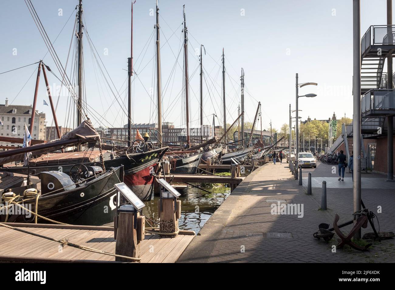 Una serie di storiche chiatte commerciali si allineavano lungo Oosterdock sul fiume Amstel ad Amsterdam, Paesi Bassi. Foto Stock