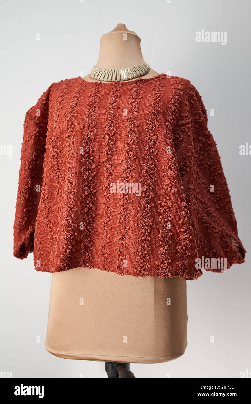 Blusa corta con nappine in terracotta. Abbigliamento formale da donna. Foto Stock