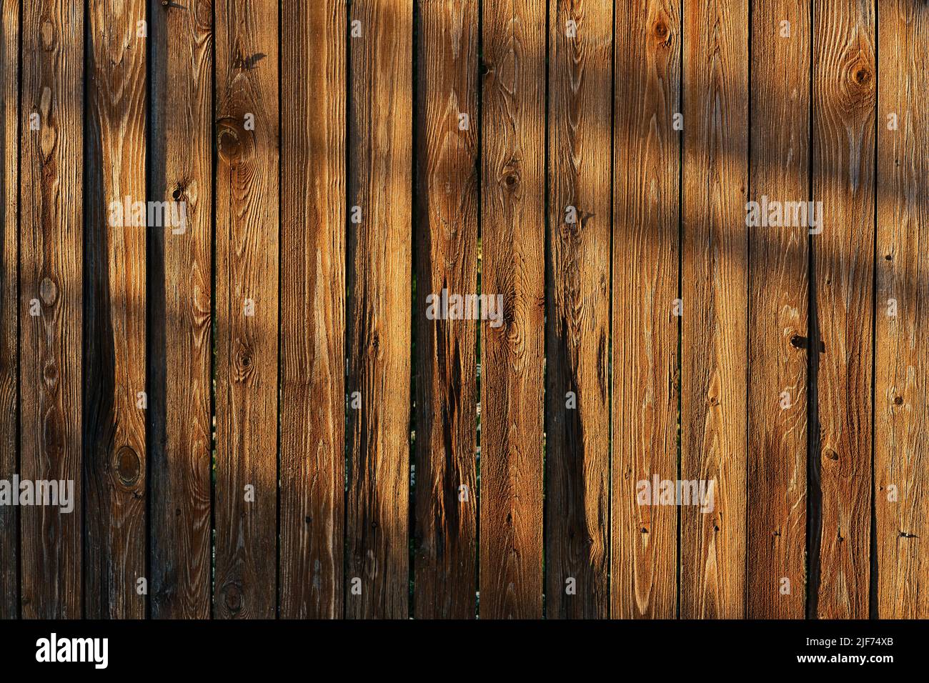 Marrone legno recinzione texture con ombre in luce del sole di sera. Sfondo di tavole di legno. Foto Stock