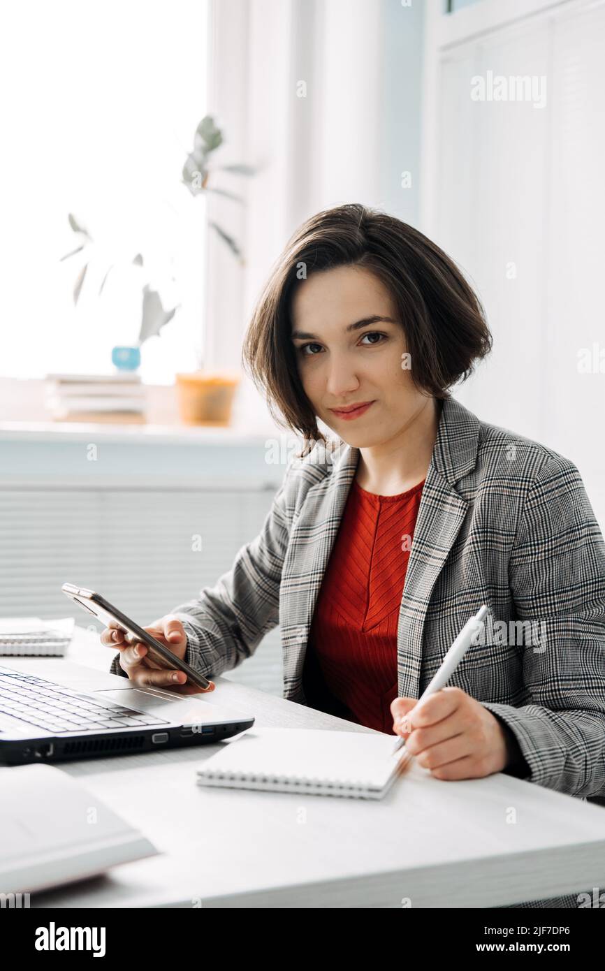Ritratto di giovane donna d'affari fiduciosa in ufficio moderno. Azienda di proprietà femminile, Foto Stock