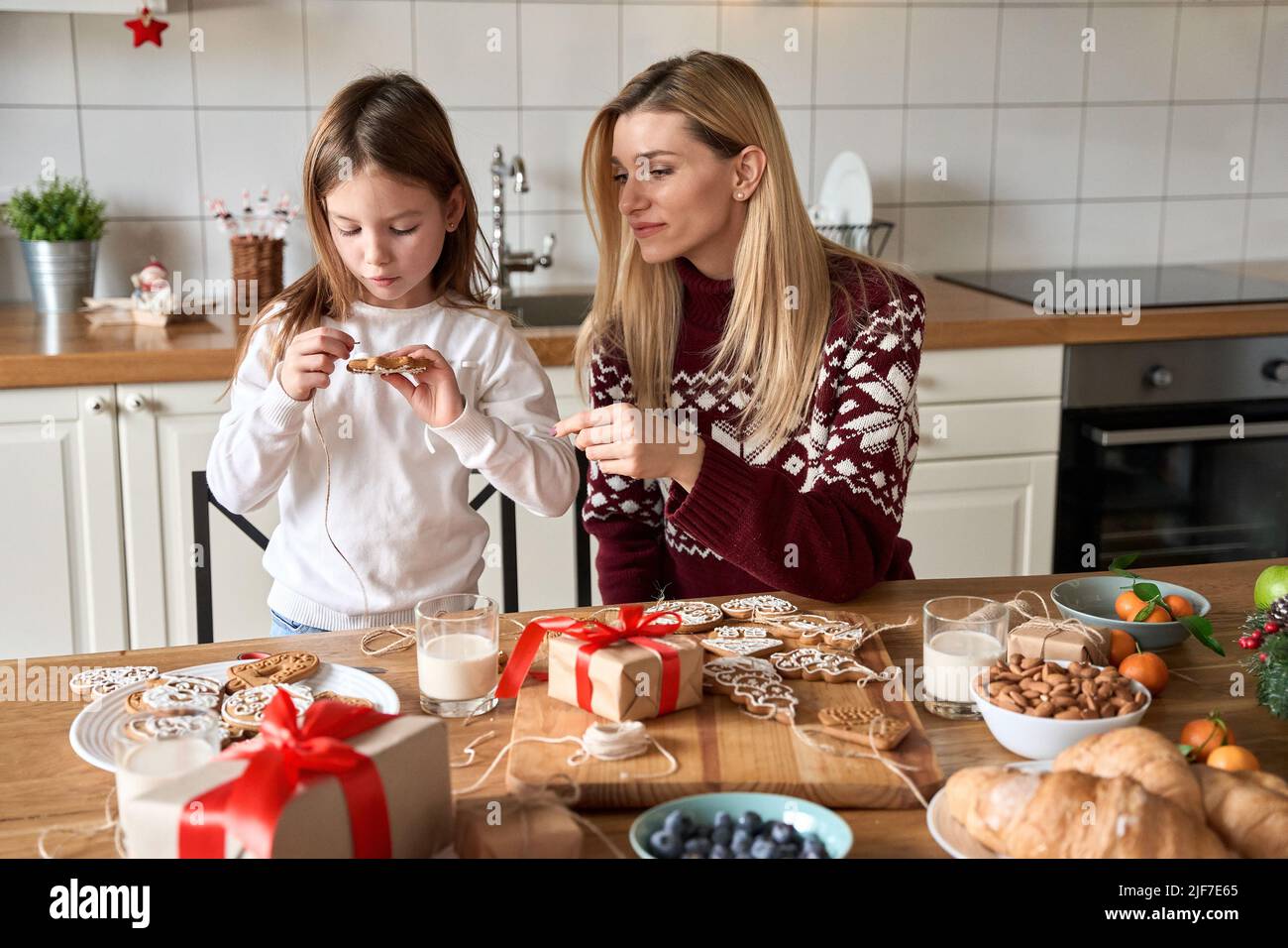 Madre e bambino che fanno le decorazioni dei biscotti di Natale insieme. Foto Stock