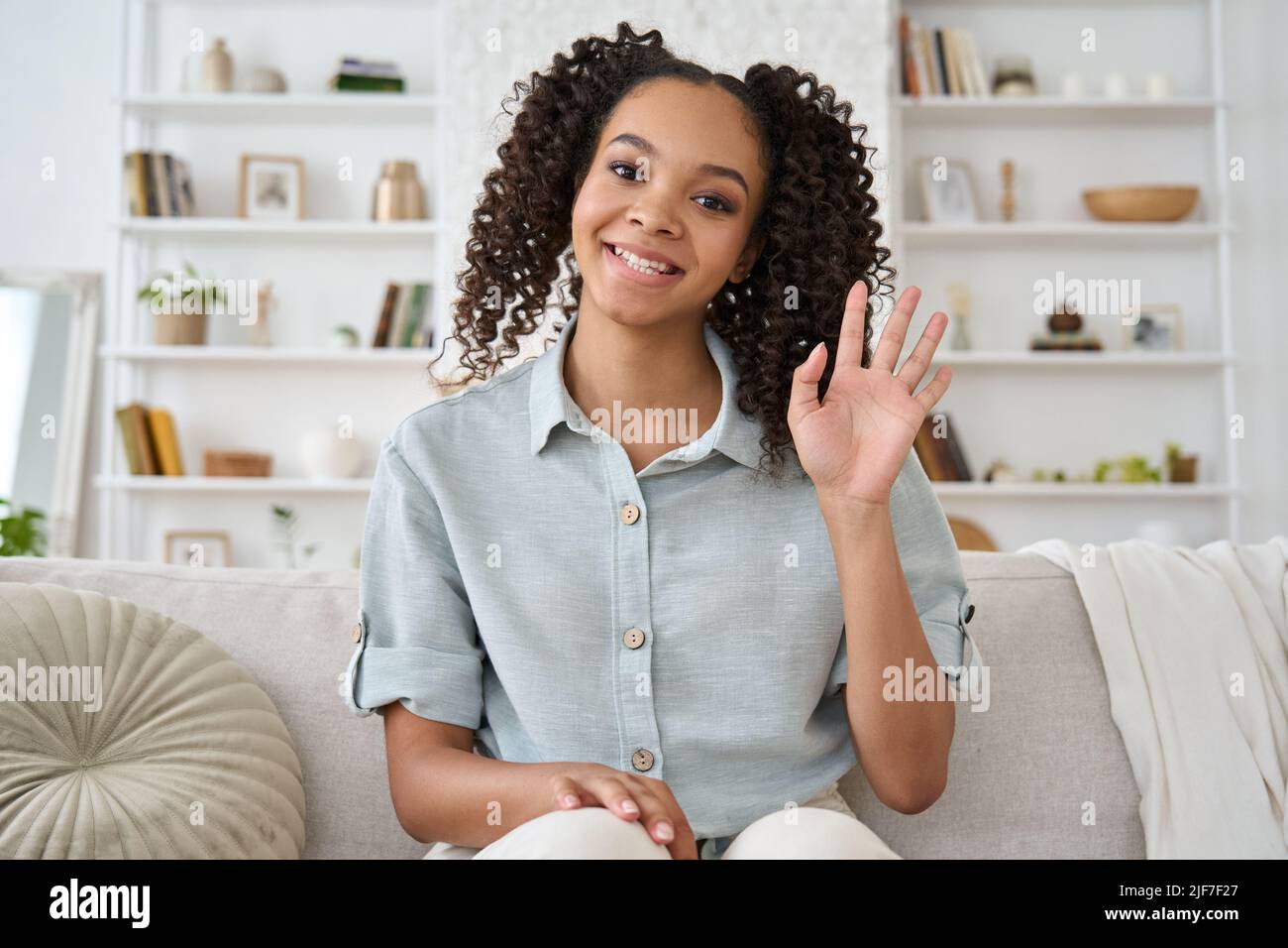 Felice ragazza teen afroamericana che agita mano guardando la macchina fotografica. Vista Webcamera Foto Stock