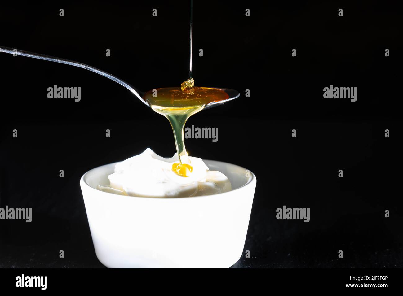 Colazione dolce con miele che scorre in un piatto di quark Foto Stock