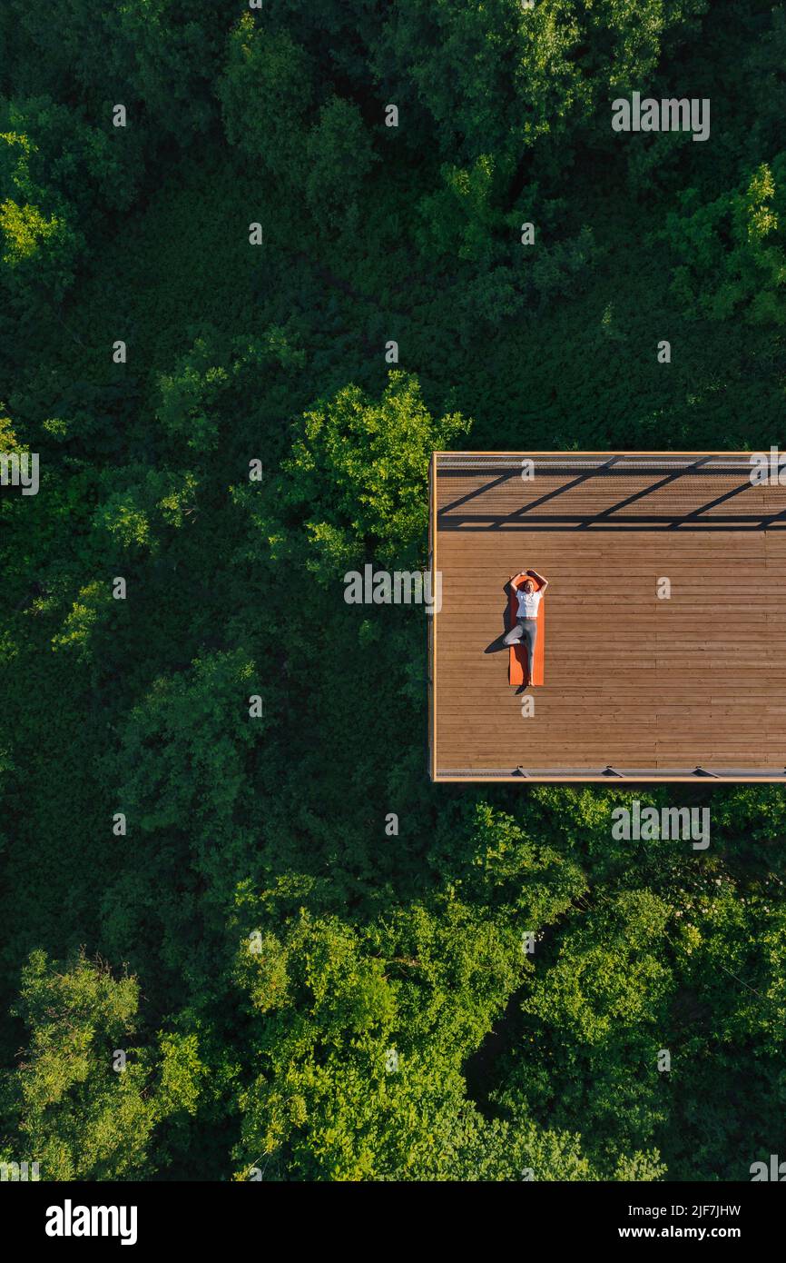 Giovane donna che fa yoga sul balcone Foto Stock