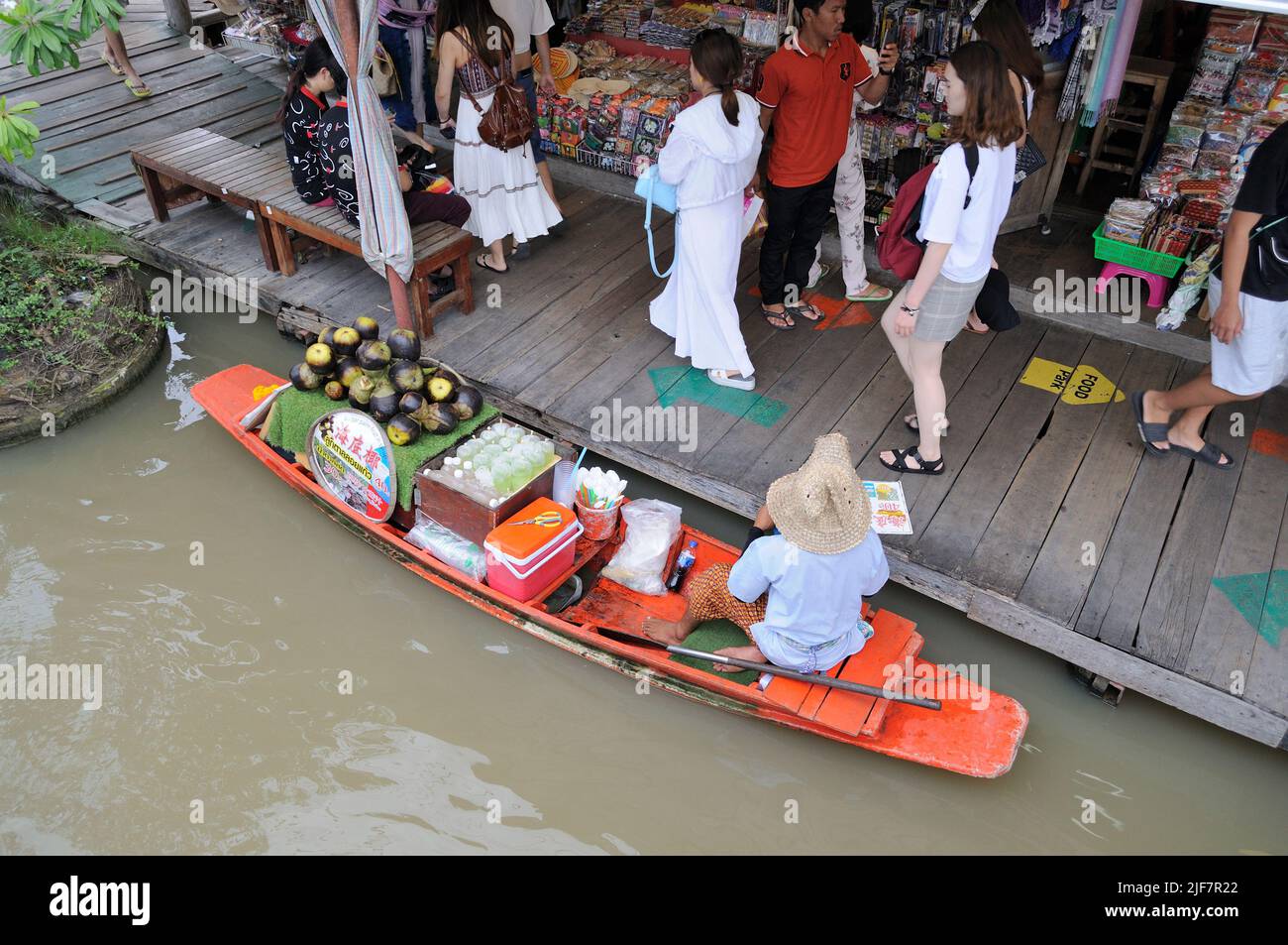 Venditore sulla barca di legno al mercato galleggiante. Foto Stock