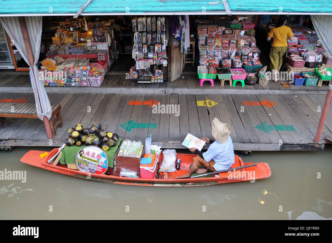 Venditore sulla barca di legno al mercato galleggiante. Foto Stock