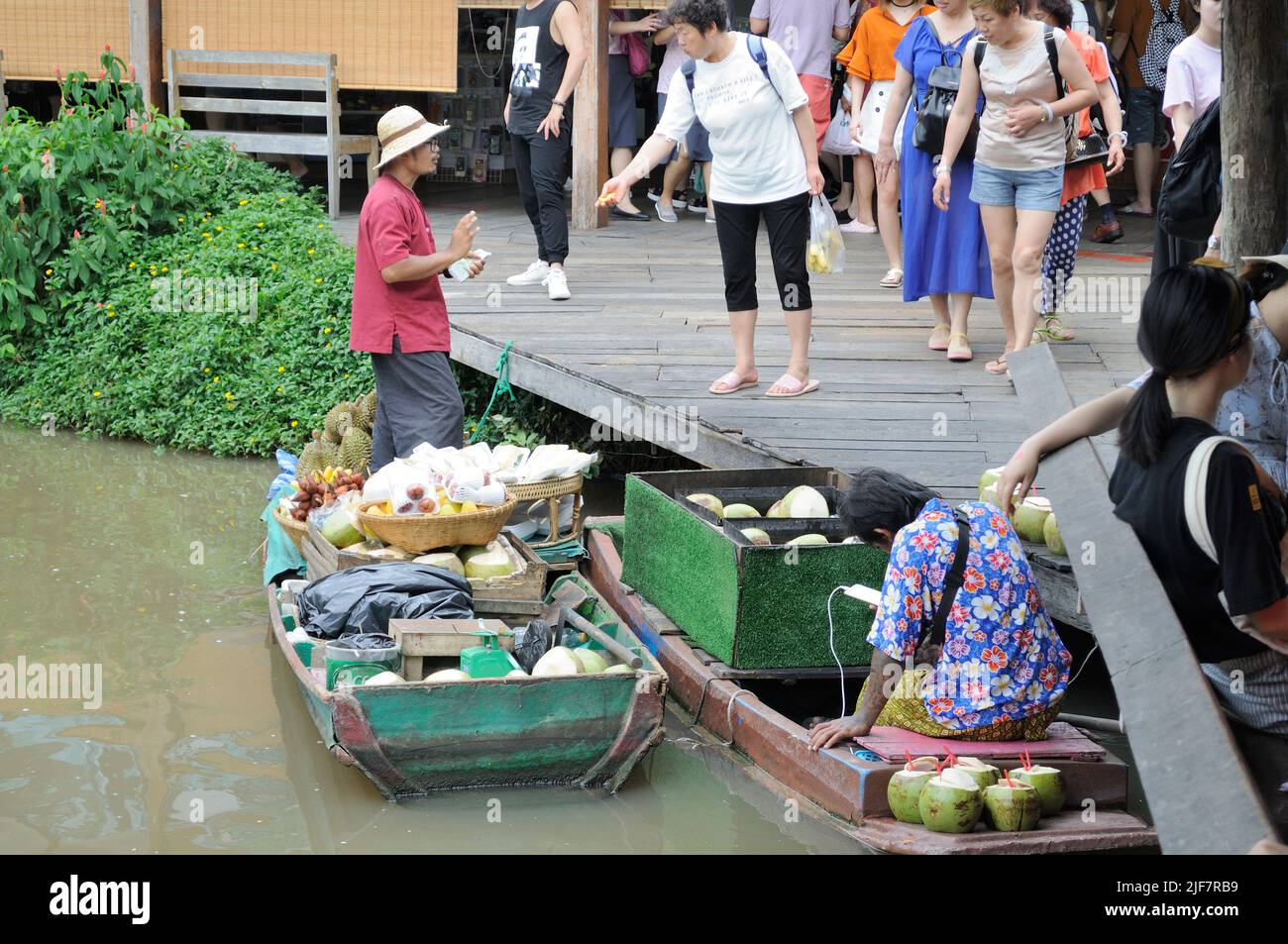 Venditore sulla barca di legno al mercato galleggiante. Foto Stock