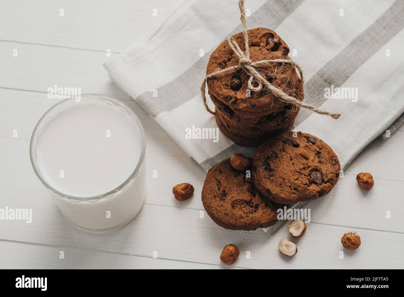 Biscotti fatti in casa e vetro riempito con latte sul tavolo bianco Foto Stock