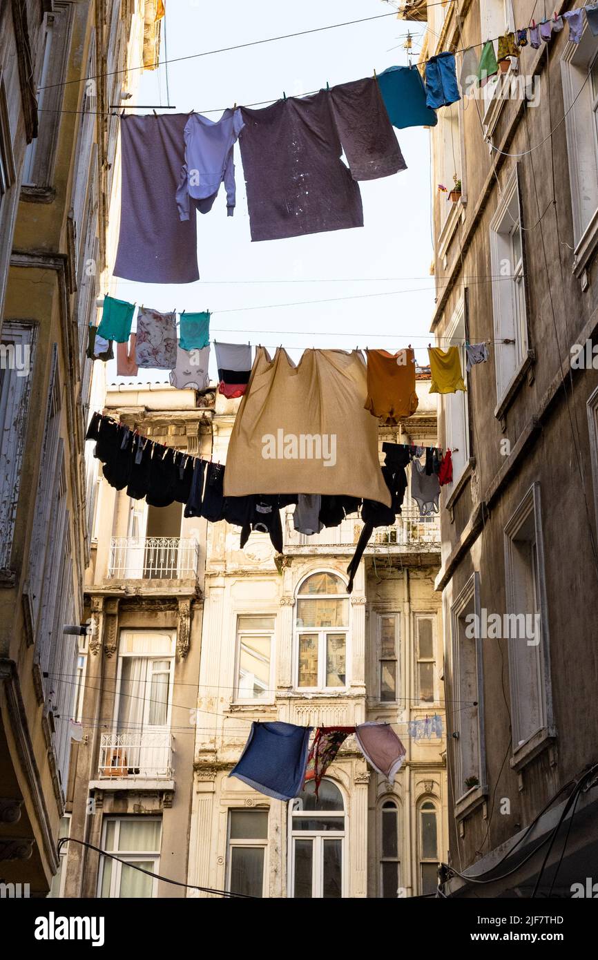 Istanbul - lavaggio appeso tra gli edifici di fronte a una strada stretta nel quartiere hacimimi a Beyoglu, Istanbul, Turchia Foto Stock