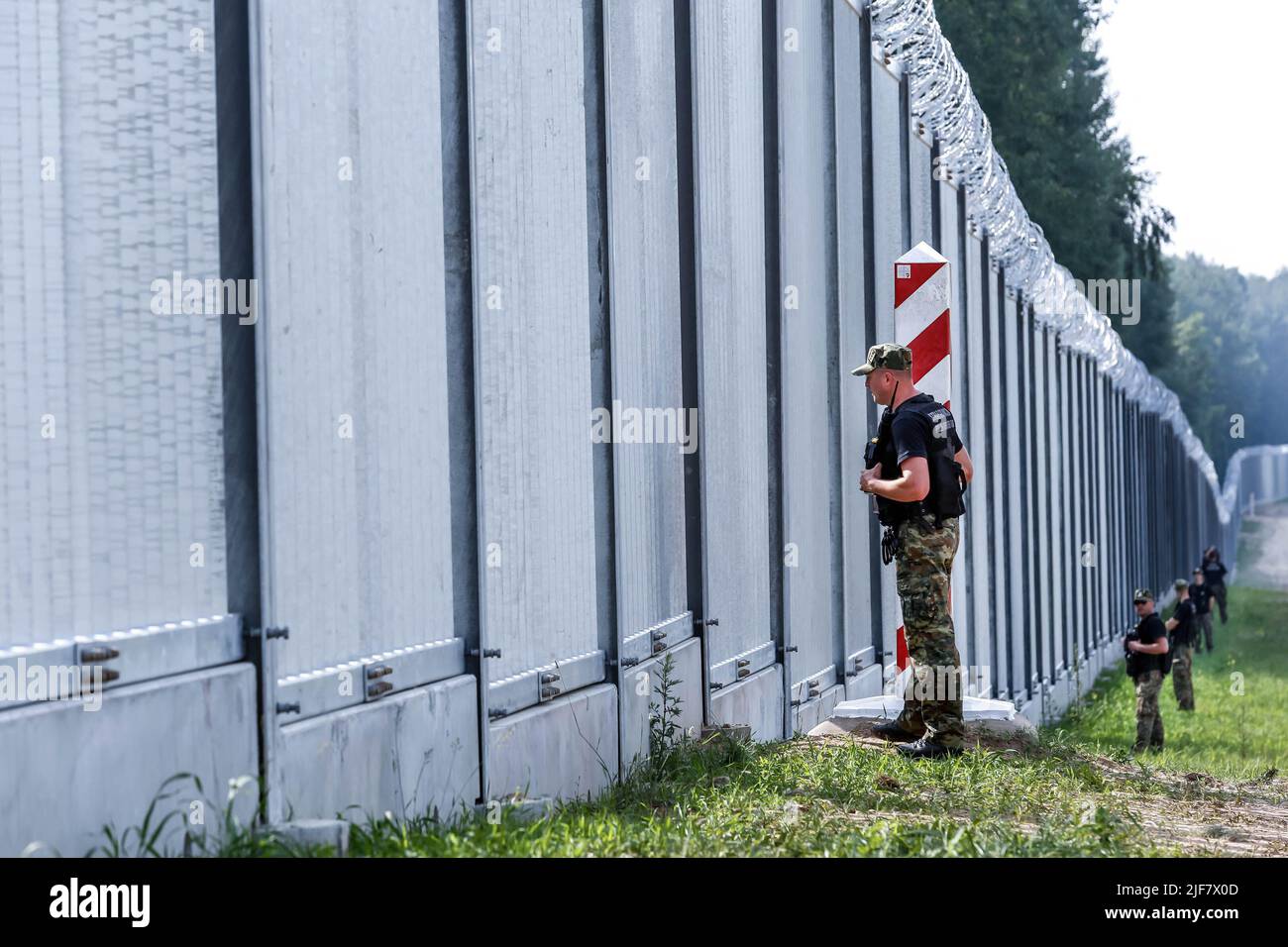 Le guardie di frontiera pattugliano le barriere fisiche costruite al confine tra Polonia e Bielorussia. La barriera fu costruita nei primi due trimestri del 2022. Il governo polacco ha deciso di costruire una barriera di acciaio lunga 186 chilometri e alta 5,5 metri con filo spinato sul confine polacco-bielorusso, che è anche il confine tra Unione europea e NATO. La decisione è stata presa dopo che migliaia di migranti, principalmente provenienti da Siria, Iraq e Afghanistan, hanno cercato di attraversare la Polonia dalla Bielorussia. Il governo bielorusso è stato accusato di orchestrare la migrazione, con l'aiuto della Russia. La pressione sul Polis Foto Stock