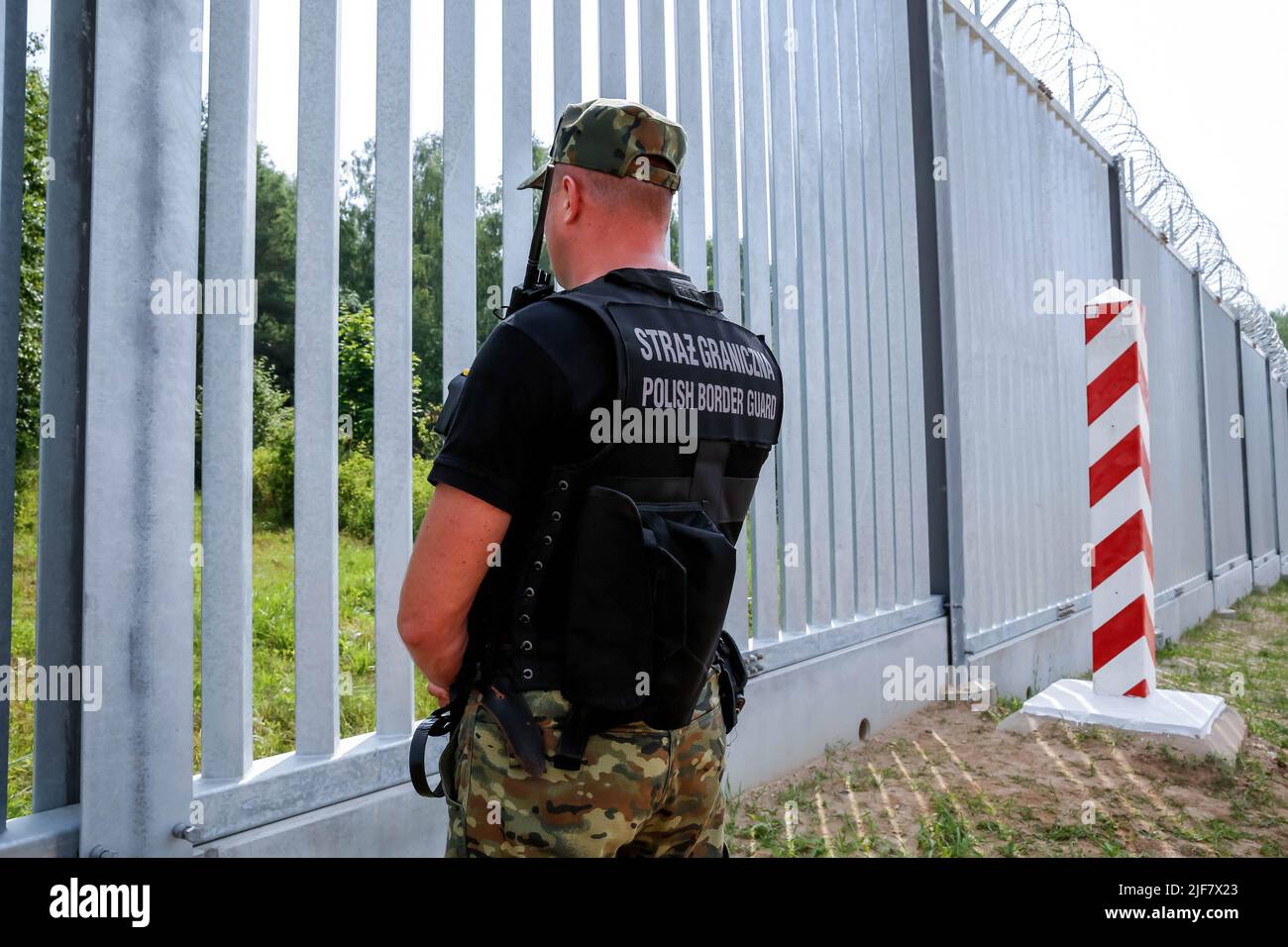 La guardia di frontiera pattuglia la barriera fisica costruita sul confine tra Polonia e Bielorussia. La barriera fu costruita nei primi due trimestri del 2022. Il governo polacco ha deciso di costruire una barriera di acciaio lunga 186 chilometri e alta 5,5 metri con filo spinato sul confine polacco-bielorusso, che è anche il confine tra Unione europea e NATO. La decisione è stata presa dopo che migliaia di migranti, principalmente provenienti da Siria, Iraq e Afghanistan, hanno cercato di attraversare la Polonia dalla Bielorussia. Il governo bielorusso è stato accusato di orchestrare la migrazione, con l'aiuto della Russia. La pressione sul polacco Foto Stock