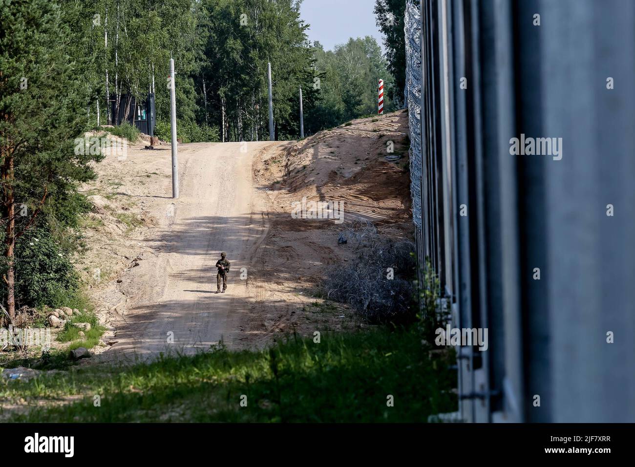 30 giugno 2022, Nowodziel, Polonia: La guardia di frontiera pattuglia le barriere fisiche costruite al confine tra Polonia e Bielorussia. La barriera fu costruita nei primi due trimestri del 2022. Il governo polacco ha deciso di costruire una barriera d'acciaio lunga 186 chilometri e alta 5,5 metri con filo spinato sul confine tra PolishÂ e Bielorussia, che è anche il confine tra l'Unione europea e la NATO. La decisione è stata presa dopo che thousandsÂ di migranti, principalmente provenienti dalla Siria, dall'Iraq e da AfghanistanÂ, tentarono di attraversare la Polonia dalla Bielorussia. Il governo della Bielorussia è stato accusato di orchestrare la migrazione, con l'aiuto di f Foto Stock