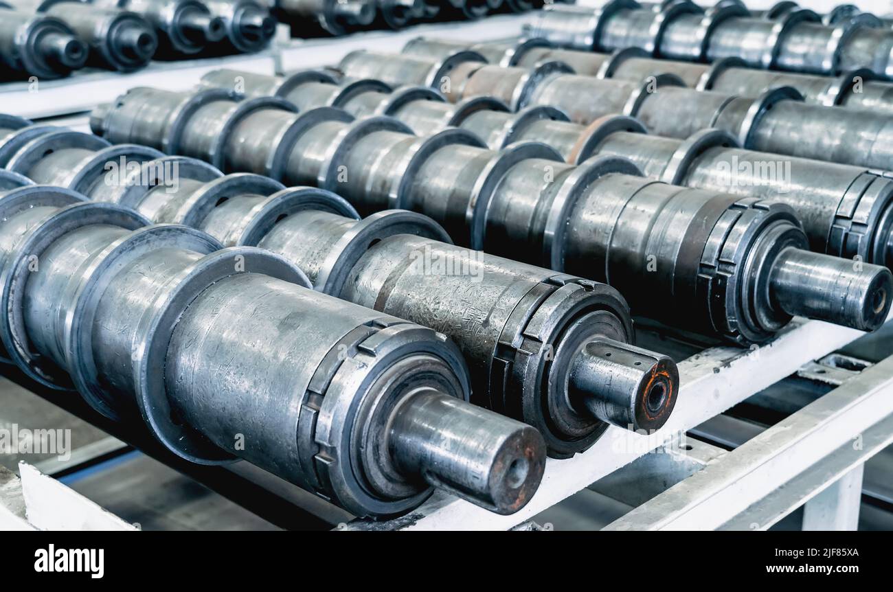 Impianto per la produzione di macchine agricole. Parti cilindriche metalliche per mietitrebbie o trattori. Foto Stock