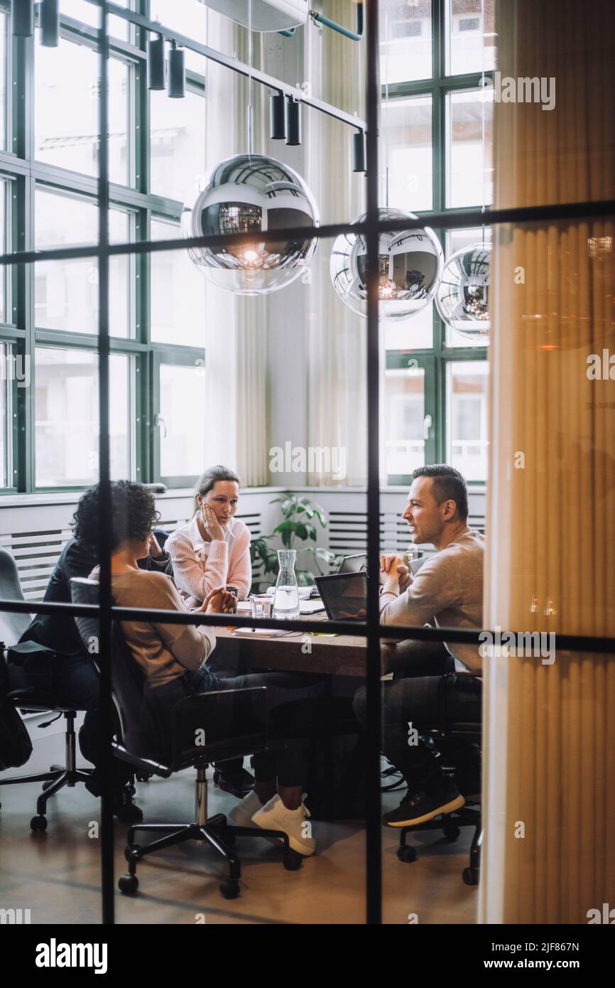 Tutta la durata dei colleghi maschi e femmine che discutono insieme nella sala riunioni Foto Stock