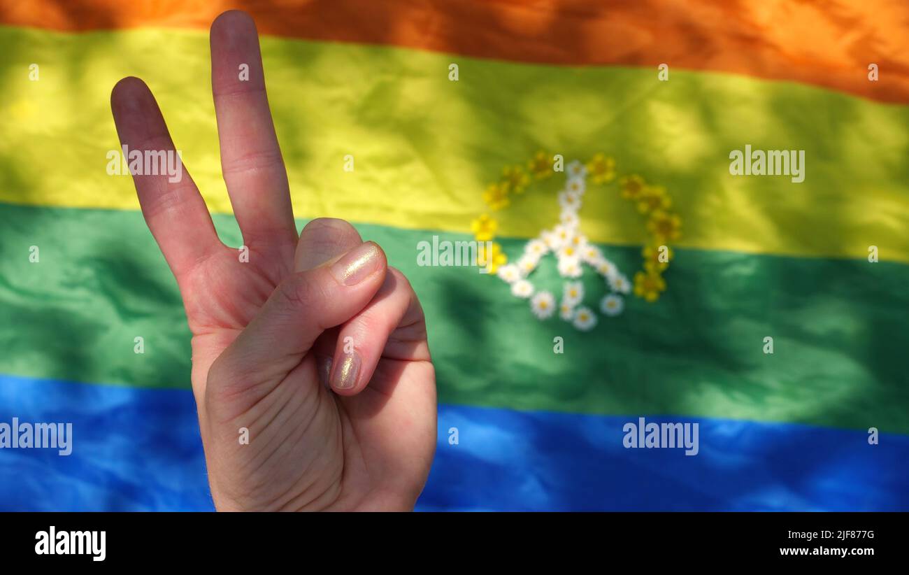 Simbolo del gesto della mano di pace sull'arcobaleno LGBT sfondo bandiera in orgoglio mese di dignità e diversità. Primo piano, copia spazio, incolla testo, giorno estivo soleggiato. Foto Stock