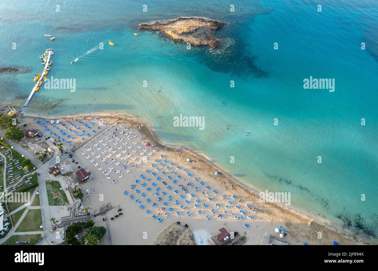Ombrelloni in fila presso la spiaggia di fichi baie Protaras Cipro. Vacanze estive resort di vacanza. Foto Stock