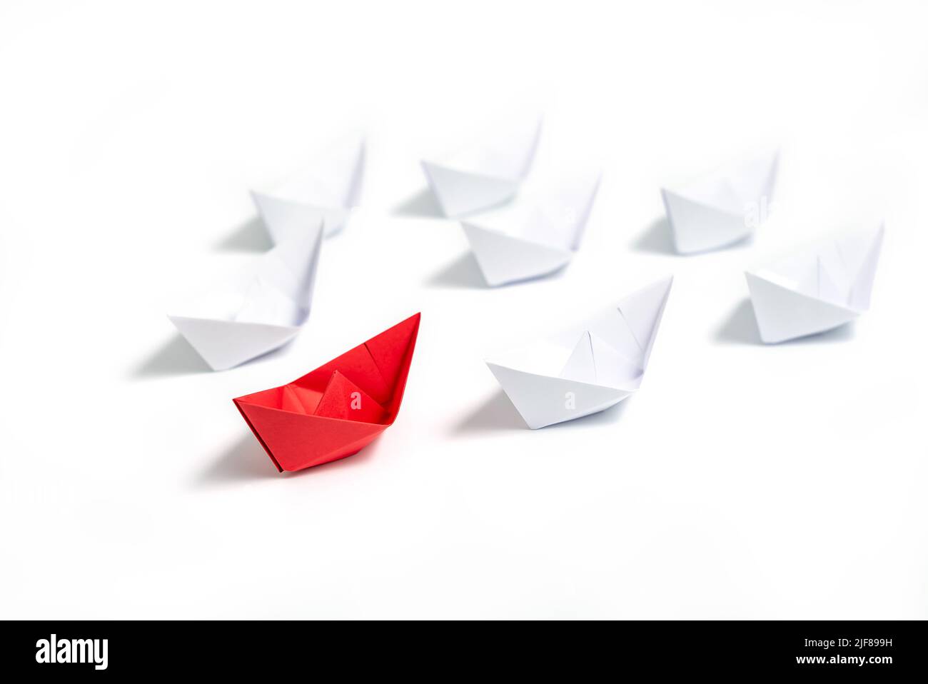 Barche di carta rossa e bianca. Concetto di barche di leadership per il gruppo di lavoro di squadra o il successo. Foto Stock