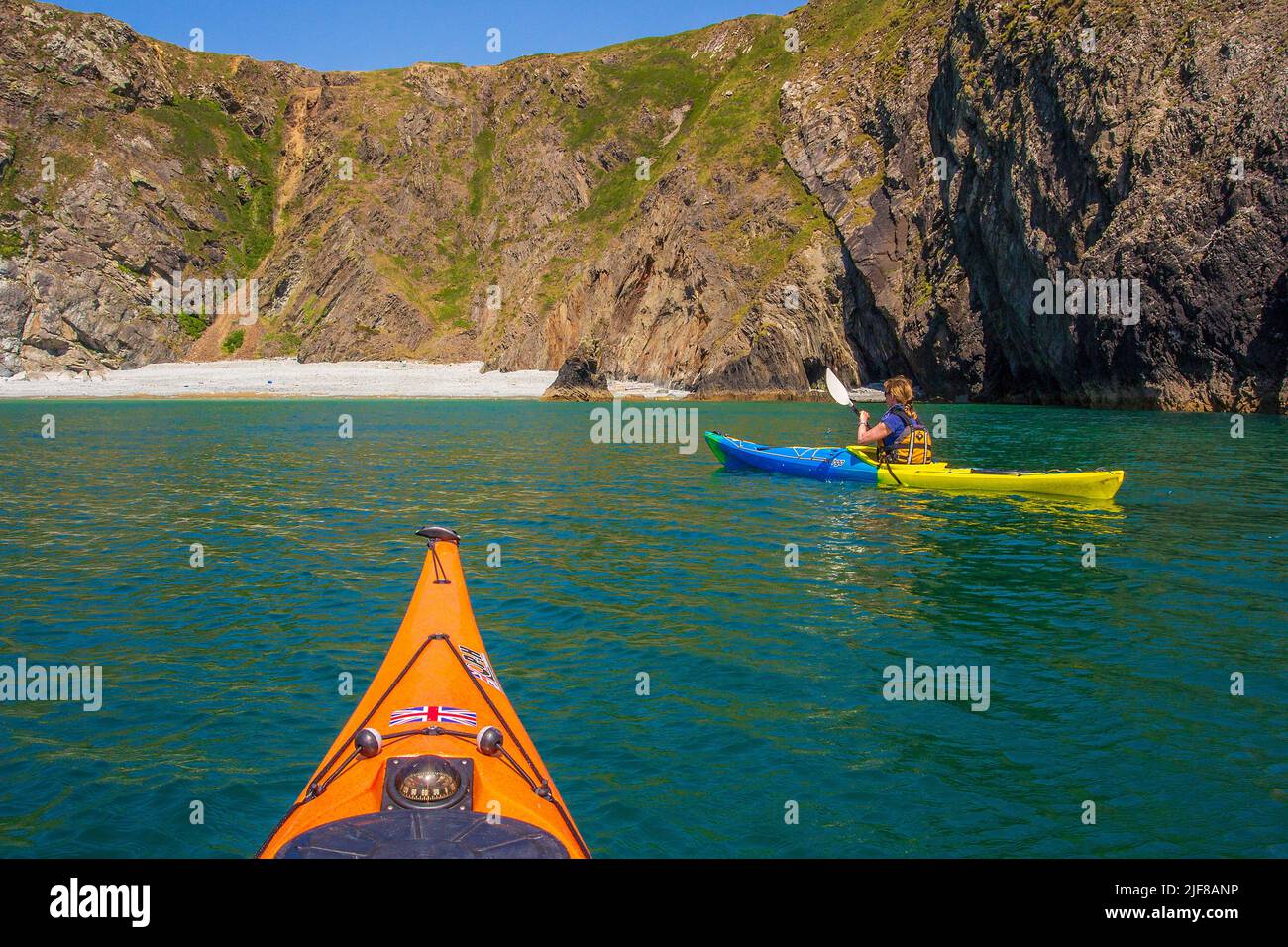 Donna / femmina kayak da mare vicino a Solva al largo della costa del Pembrokeshire in Galles Foto Stock